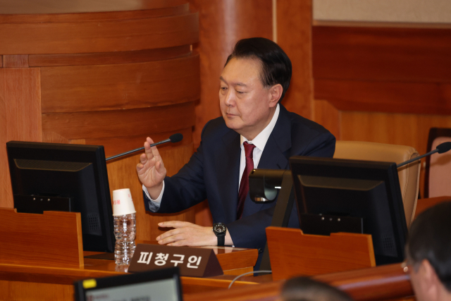 윤석열 대통령이 지난 달 23일 서울 종로구 헌법재판소에서 열린 탄핵심판 4차 변론에 출석해 마이크를 만지고 있다. 연합뉴스