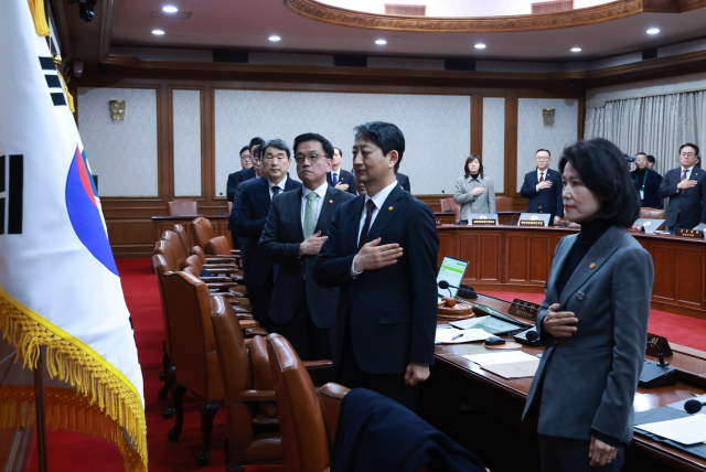 최상목 대통령 권한대행 부총리 겸 기획재정부 장관과 국무위원들이 4일 정부서울청사에서 열린 국무회의에서 국기에 경례를 하고 있다. 연합뉴스