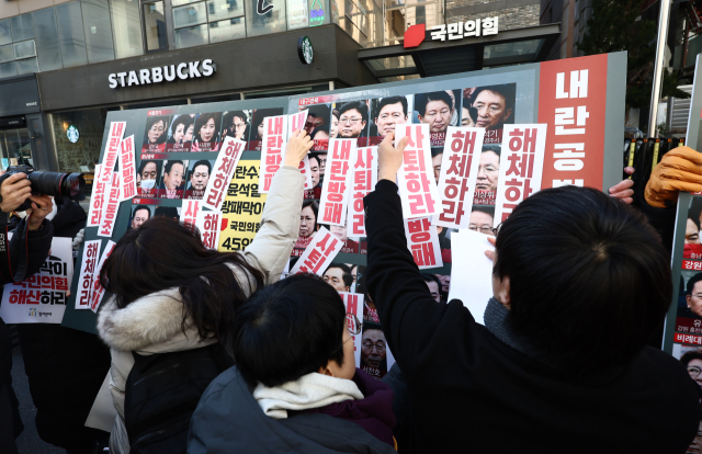 참여연대·윤석열즉각퇴진사회대전환 서울비상행동 관계자들이 지난달 10일 서울 여의도 국민의힘 당사 앞에서 열린 내란 우두머리 윤석열 방패 자처 국민의힘 해체 촉구 기자회견에 당 해체 촉구 퍼포먼스를 하고 있다. 뉴스1