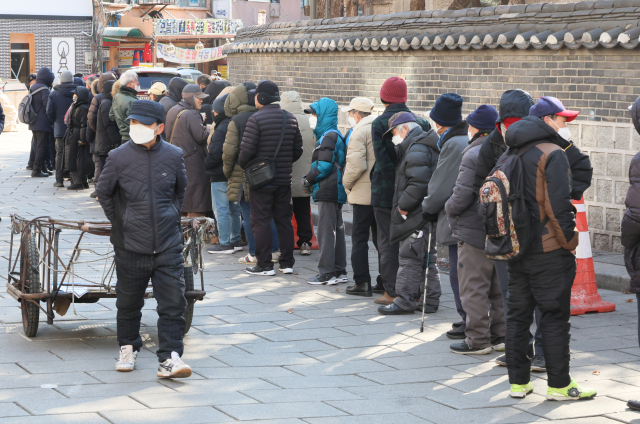 3일 서울 종로구 탑골공원 원각사 노인무료급식소 앞에 어르신들이 점심식사를 위해 줄지어 서 있다. 연합뉴스