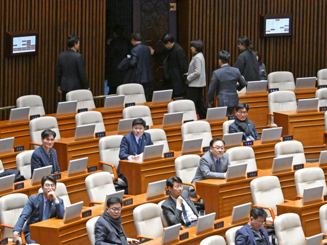 윤상현 국민의힘 의원이 12일 서울 여의도 국회 본회의장에서 열린 정치·외교·통일·안보 대정부질문에서 질의를 하려 하자 야당 의원들 몇몇이 회의장을 떠나고 있다.