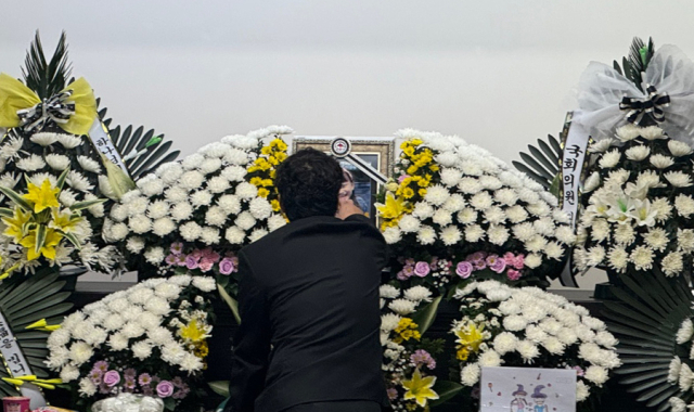 12일 대전 서구 한 초등학교에서 40대 교사에게 살해된 김하늘양의 아버지가 건양대병원 장례식장에 마련된 빈소에서 하늘양의 영정사진을 어루만지고 있다. 뉴스1