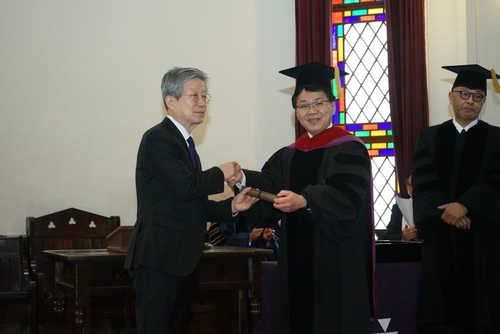 도시샤대가 16일 연 명예 박사학위 수여식에서 윤동주 시인의 조카 윤인석 성균관대 명예교수(왼쪽)와 고하라 가쓰히로 총장이 악수하는 모습. 사진 제공=주오사카총영사관