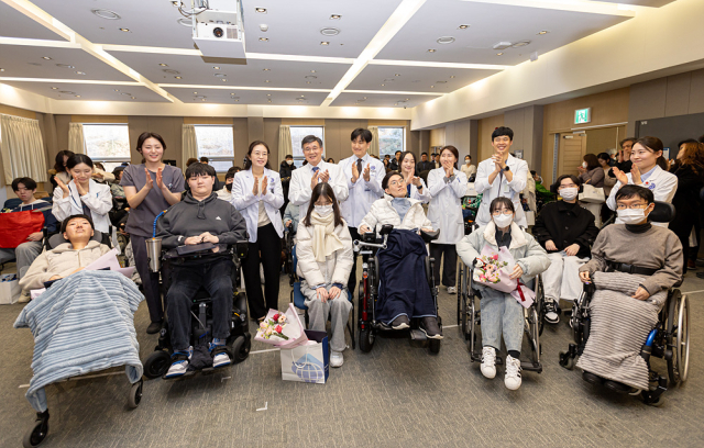 생명보험재단이 18일 강남세브란스병원에서 개최한 ‘특별한 졸업식, 희망의 입학식’ 행사에서 희귀 근육병을 이겨내고 학업의 뜻을 이룬 환우들이 의료진과 함께 기념 촬영을 하고 있다. 사진 제공=생명보험재단