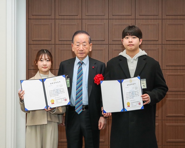 이동건 국제로타리 전 세계회장이 장학생 심예진(좌, 홍익대), 김승기(우, 단국대)에게 장학금을 전달하고 있다