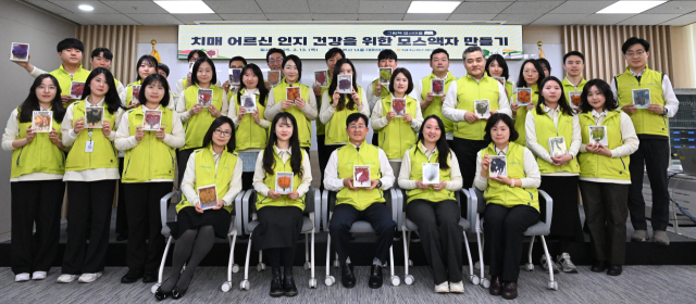 송춘수(앞줄 왼쪽 세 번째) NH농협손보 대표와 헤아림 봉사단 단원들이 공기정화액자를 들고 기념 촬영을 하고 있다. 사진 제공=NH농협손보