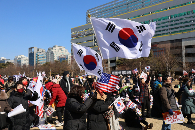 22일 대전 서구 대전시청 앞 보라매공원에서 열린 세이브코리아 국가비상기도회에서 참석자들이 윤석열 대통령 탄핵 반대를 외치며 태극기를 흔들고 있다. 대전=연합뉴스