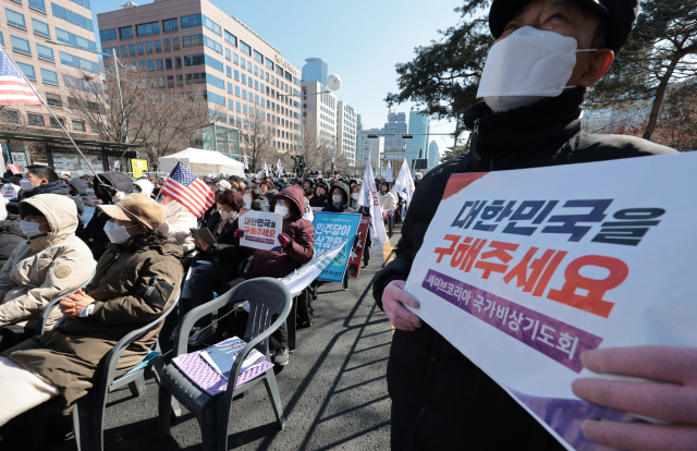 22일 서울 영등포구 국회의사당역 앞에서 열린 세이브코리아 국가비상기도회에서 참석자들이 윤석열 대통령 탄핵 반대를 촉구하는 손팻말을 들고 있다. 연합뉴스