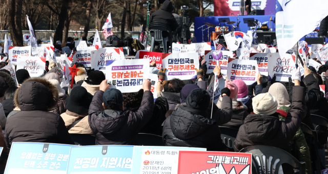 22일 서울 영등포구 국회의사당역 앞에서 열린 세이브코리아 국가비상기도회에서 참석자들이 윤석열 대통령 탄핵 반대를 촉구하는 손팻말을 들고 있다. 연합뉴스