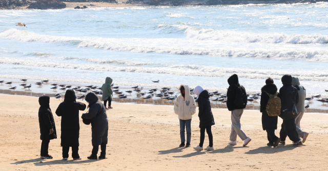 인천 중구 을왕리해수욕장을 찾은 시민들이 겨울철 바람 속에서 해변을 걷고 있다. 인천=연합뉴스