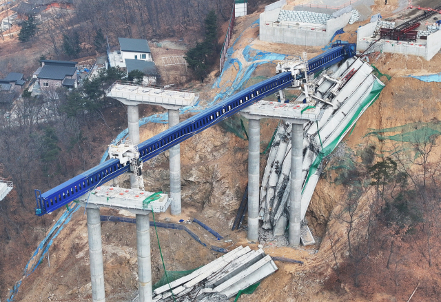 지난 25일 서울세종고속도로 건설 현장에서 교각 위에 설치 중이던 교량 상판 구조물이 무너져 내리면서 상부에서 추락한 근로자 10명이 숨지거나 다쳤다. 사진은 26일 사고 현장 모습. 연합뉴스