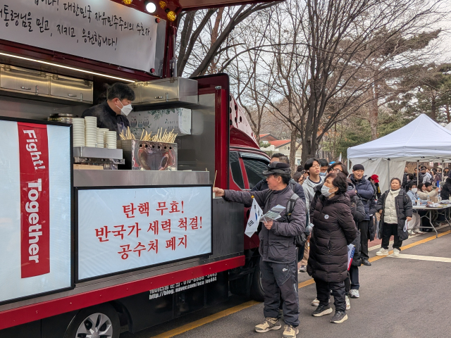 봉사자와 상인들이 트럭에서 어묵을 나눠주고 있다. 황동건 기자