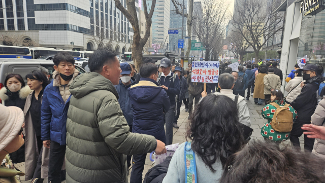 보수단체 집회가 진행되고 있는 서울 교보문고 본사 앞 거리에서 윤 대통령 비판 피켓을 들고 이동하는 진보단체 지지자를 향하 보수단체 지지자들이 욕설을 하는 모습. 채민석 기자