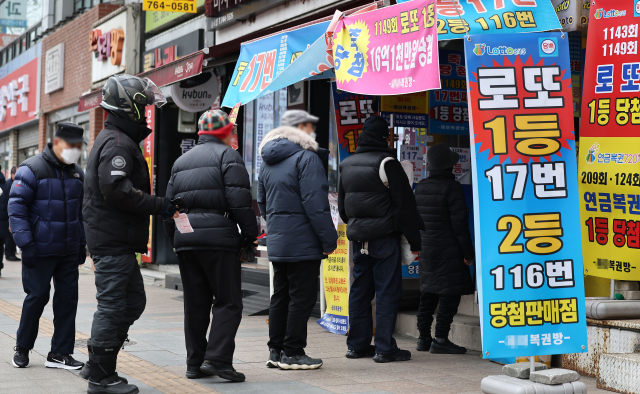 1월 30일 오후 ‘로또명당’으로 알려진 서울 종로구의 한 복권판매점 앞에 시민들이 복권 구입을 위해 줄을 서 있다. 연합뉴스