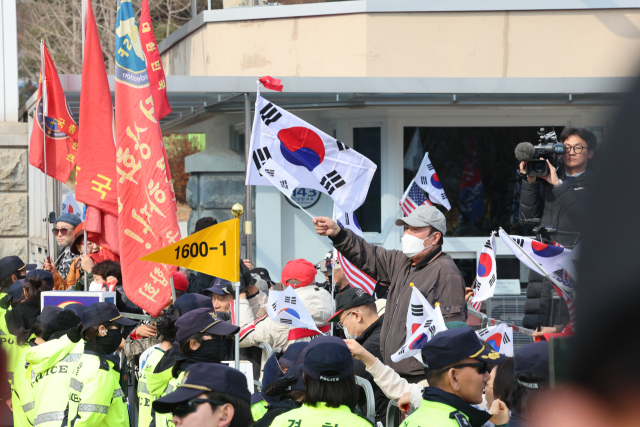 법원이 내란 수괴 혐의로 구속기소된 윤석열 대통령의 구속 취소를 인용한 7일 경기 의왕시 서울구치소 앞에서 윤 대통령 지지자들이 구호를 외치고 있다. 뉴스1