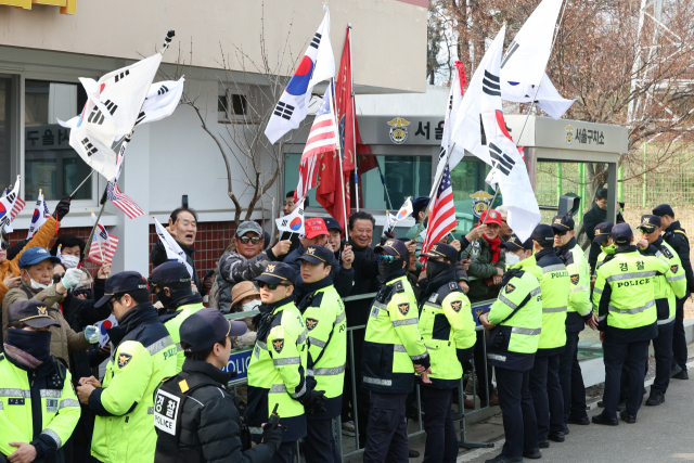 비상계엄 사태와 관련해 '내란 우두머리' 혐의로 구속기소 된 윤석열 대통령이 구금 51일 만에 석방된 7일 경기도 의왕시 서울구치소 앞에서 지지자들이 구호를 외치고 있다. 연합뉴스