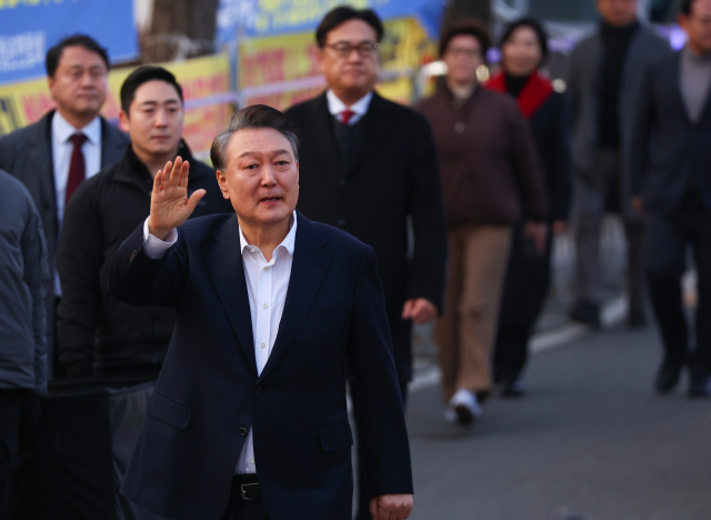 석방된 윤석열 대통령이 8일 경기도 의왕시 서울구치소 앞에서 경호차량에서 내려 걸어가며 지지자들에게 인사하고 있다. 연합뉴스