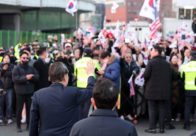 법원의 구속취소 청구 인용으로 석방된 윤석열 대통령이 8일 오후 서울 용산구 한남동 대통령 관저 앞 지지자들에게 인사하고 있다. 뉴스1