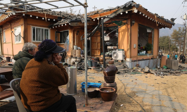 지난 7일 경기도 포천시 이동면 노곡리 공군 전투기 오폭 사고 현장에서 피해 주민들이 파손된 집을 바라 보고 있다. 연합뉴스