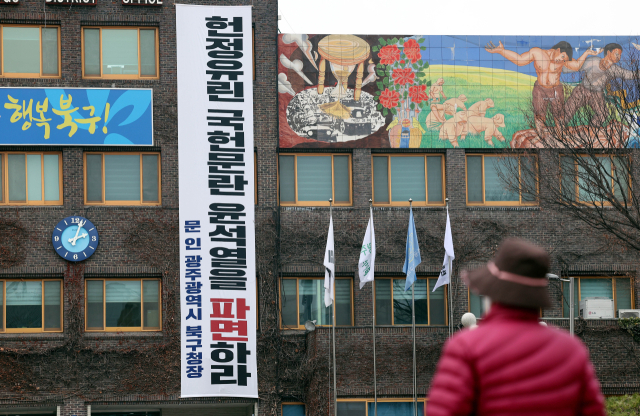 12일 광주 북구청 청사 외벽에 문인 구청장이 윤석열 대통령 파면을 촉구하는 내용을 담아 제작한 현수막이 걸려 있다. 연합뉴스