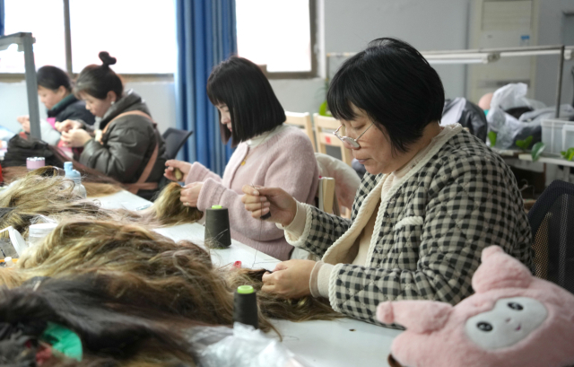 중국 동부 산둥성 허즈시의 한 가발 공장에서 13일 근로자들이 가발 제품을 만들고 있다. 신화연합