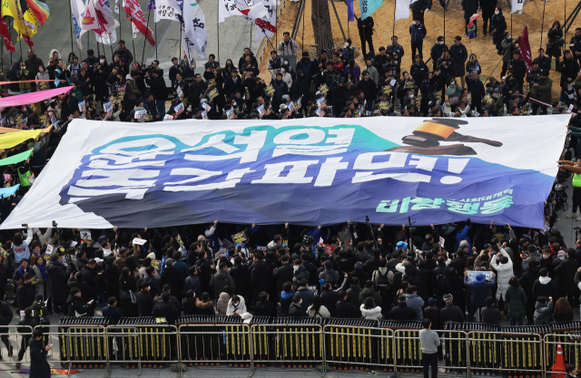 윤석열 즉각퇴진·사회대개혁비상행동 주최로 17일 서울 종로구 광화문광장에서 열린 윤석열 즉각 파면 촉구 각계 긴급시국선언 집회에서 현수막 퍼포먼스가 진행되고 있다. 연합뉴스