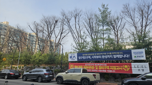 서울 강남구 압구정동 신현대아파트 단지 내 건설사들의 ‘정비구역 지정 고시’ 축하 현수막이 걸려 있다. 백주연 기자