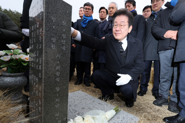 18일 광주 북구 운정동 국립5·18민주묘지에서 이재명 더불어민주당 대표가 박병규 열사 묘역을 찾아 묘비를 살펴보고 있다. 연합뉴스