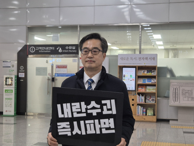 김동연 경기도지사가 11일 오전 경기도청 인근 신분당선 광교중앙역 개찰구 앞에서 '내란수괴 즉시파면'이라는 문구가 적힌 푯말을 들고 출근길 시민들을 대상으로 20여분간 1인 시위를 진행했다. 사진은 김 지사가 1인 시위를 진행 중인 모습. 연합뉴스