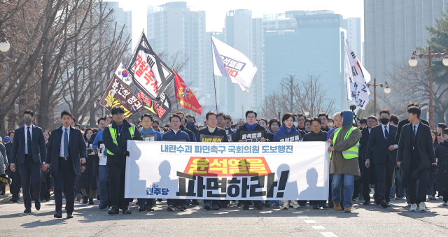 경찰의 신변보호를 받게 되면서 장외 활동을 재개한 이재명 더불어민주당 대표가 19일 윤석열 대통령 파면을 촉구하는 국회의원 도보행진에 동참해 여의도 국회에서 광화문으로 향하고 있다.연합뉴스