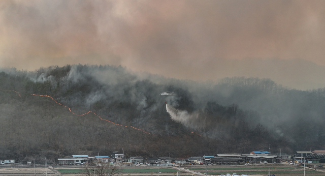 22일 경북 의성군 의성읍 원당2리 마을 인근까지 산불이 번진 가운데 산불진화헬기가 진화 작업에 나서고 있다. 의성=연합뉴스