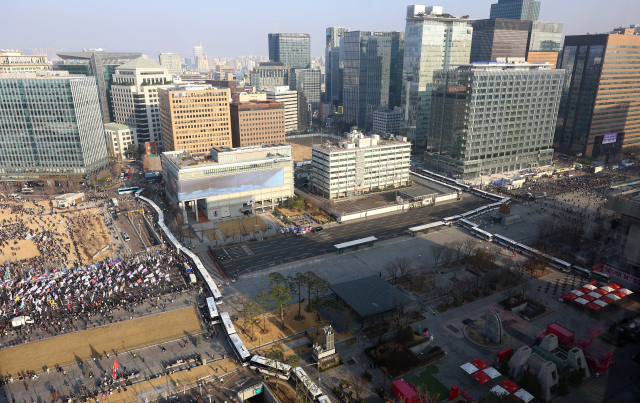 22일 오후 서울 광화문광장에 경찰버스로 가로막힌 완충지대가 만들어진 가운데 왼쪽에서는 윤석열 대통령 탄핵 촉구 집회, 오른쪽에는 탄핵 반대 집회가 진행되고 있다. 연합뉴스