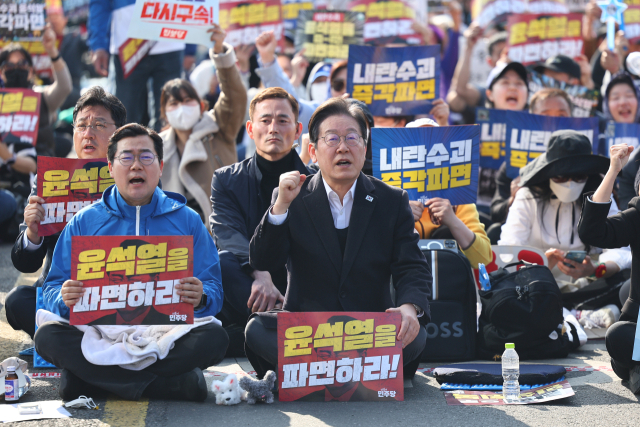 더불어민주당 이재명 대표와 박찬대 원내대표가 22일 서울 종로구 동십자각 앞에서 열린 야5당 공동 비상시국 범국민대회에서 구호를 외치고 있다. 연합뉴스