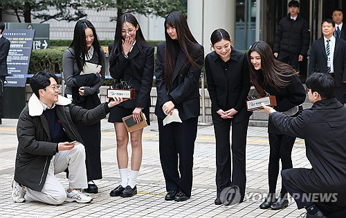 걸그룹 뉴진스가 3월 7일 서울 서초구 서울중앙지방법원에서 열린 '기획사 지위보전 및 광고계약 체결 등 금지' 가처분 신청의 심문기일을 마친 뒤 법원 청사를 나서며 취재진 질문에 답하고 있다. 왼쪽부터 하니, 민지, 혜인, 해린, 다니엘. 연합뉴스