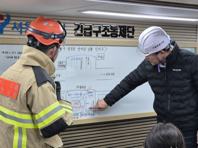 오세훈(오른쪽) 서울시장이 24일 강동구 명일동 싱크홀 현장을 찾아 상황을 보고받고 있다. 사진 제공=서울시