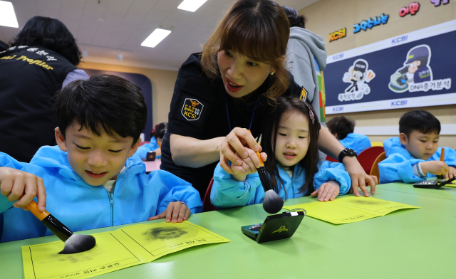 22일 인천 남동구 인천경찰청에서 열린 ‘KCSI 과학수사 체험교실’에 참가한 어린이들이 지문 채취 체험을 하고 있다. 연합뉴스