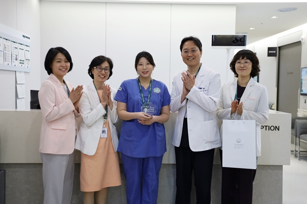 최애리(왼쪽 세 번째) 이대목동병원 간호사가 28일 국립괴산호국원으로부터 감사패를 수상하고 동료 의료진의 축하를 받고 있다. 사진 제공=이화의료원