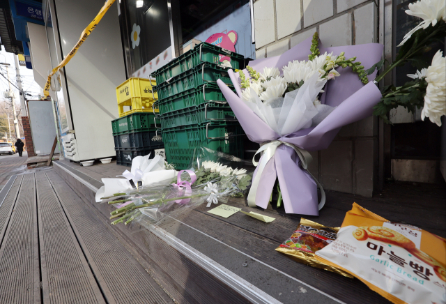 2월 14일 오후 경기 시흥시의 한 편의점 앞에 추모의 글귀가 적힌 쪽지와 국화 꽃다발, 간식 등이 놓여있다. 연합뉴스