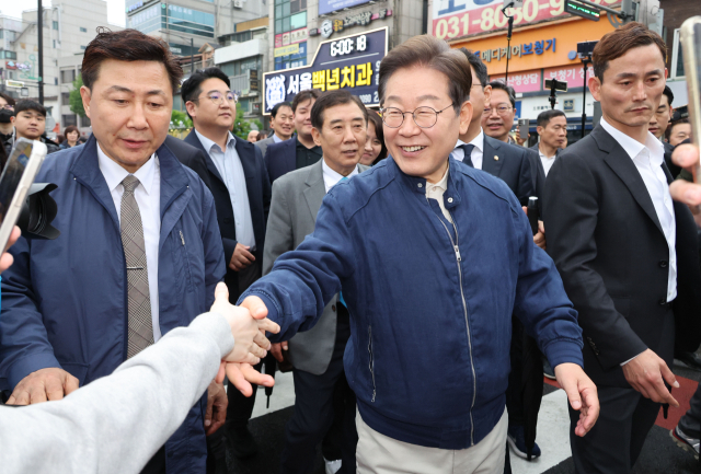 이재명(가운데) 더불어민주당 대선 후보가 1일 경기도 포천 시내에서 한 시민과 악수하고 있다. 이날 이 후보는 전국 각지에서 민심을 듣는 '골목골목 경청투어' 첫날을 소화했다.