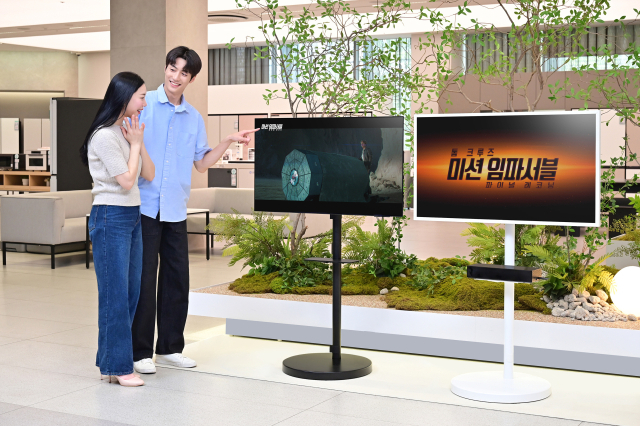 삼성전자 모델들이 2025년형 OLED TV, 더 프레임 TV와 결합된 무빙스타일로 영화 ‘미션 임파서블: 파이널 레코닝’ 예고편을 보고 있다. 삼성전자는 TV 신제품의 높은 명암비와 생생한 화질을 강조하기 위해 전국 삼성스토어 매장에서 예고편을 상영한다고 2일 밝혔다. 사진제공=삼성전자