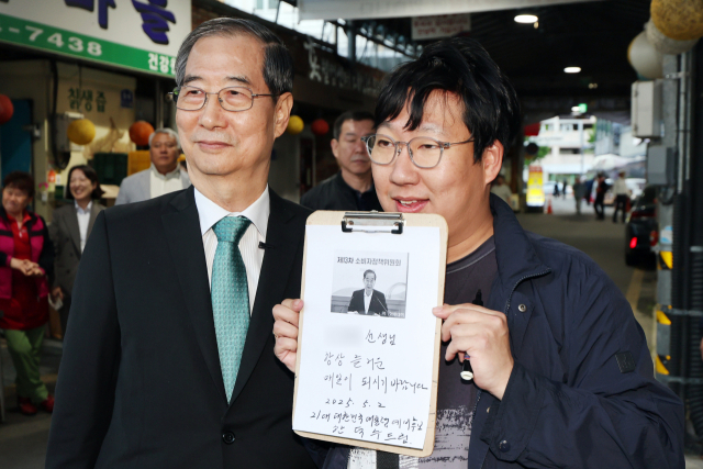 2일 광주 동구 대인시장에서 한덕수 전 국무총리가 지지자와 만나 기념사진을 찍고 있다. 연합뉴스