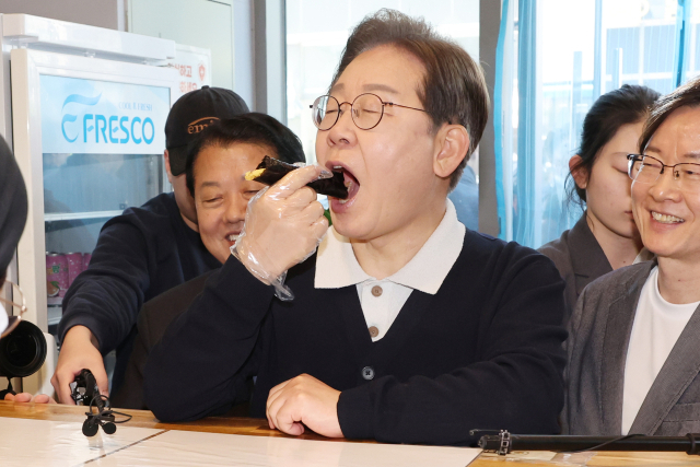 이재명 더불어민주당 대선 후보가 '골목골목 경청투어' : 단양8경편'에 나선 4일 경북 예천군 도청신도시에서 김밥집에 들러 상인과 대화를 하며 꼬마김밥을 사먹고 있다. 연합뉴스