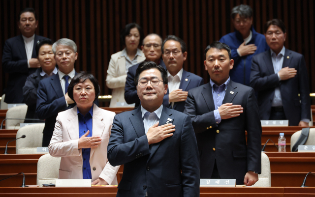 박찬대 더불어민주당 원내대표를 비롯한 의원들이 4일 국회에서 열린 긴급 의원총회에서 국기에 경례를 하고 있다. 연합뉴스