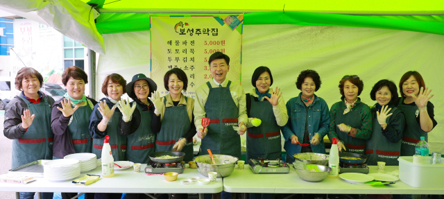 김철우(가운데) 보성군수가 제48회 보성다향대축제 기간 중 문을 연 보성문화예술회관 일원에 마련된 보성주막집 부스에서 새마을부녀회 회원들과 기념촬영을 하고 있다. 사진 제공=보성군