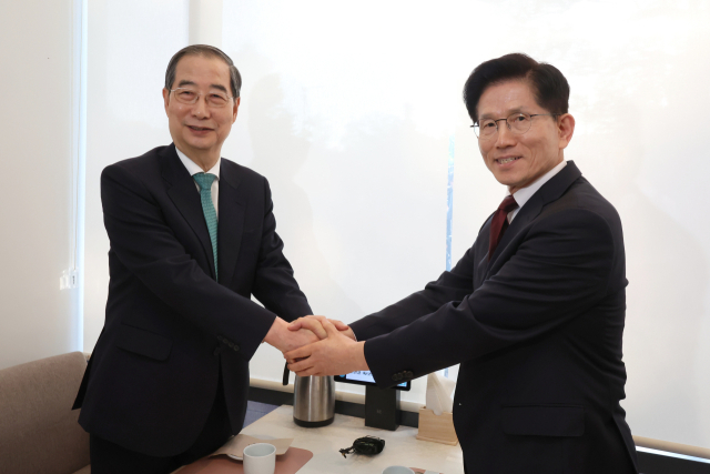 국민의힘 김문수 대선후보(오른쪽)와 무소속 한덕수 대선 예비후보가 7일 서울 종로구의 한 식당에서 후보 단일화 관련 회동을 하기 전 악수하고 있다. 연합뉴스
