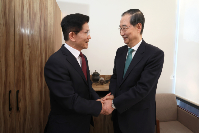 김문수(왼쪽) 국민의힘 대선후보와 한덕수 무소속 대선 예비후보가 7일 서울 종로구의 한 식당에서 후보 단일화 관련 회동을 시작하기 전 악수하고 있다. 연합뉴스