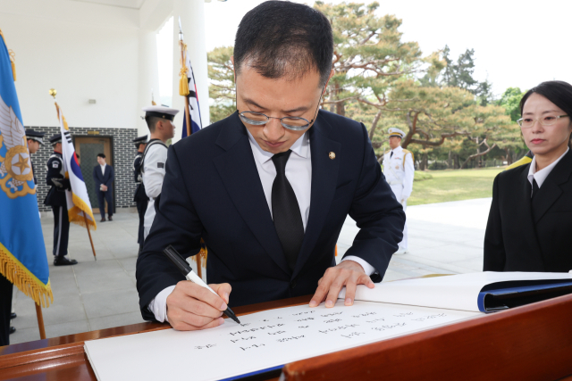 탈당 압박을 받아온 김상욱 국민의힘 의원이 8일 서울 동작구 현충원을 참배한 뒤 방명록을 작성하고 있다. 김 의원은 이날 