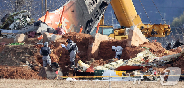 제주항공 여객기 참사 7일째인 지난 1월 4일 전남 무안국제공항 참사 현장에서 항공·철도사고 조사위원회(ARAIB) 관계자들이 제주항공 7C2216편의 엔진이 파묻혀있던 로컬라이저(방위각시설) 둔덕을 살펴보고 있다. 무안=뉴스1