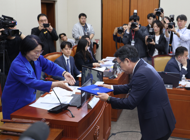 8일 국회 과학기술정보방송통신위원회 전체회의에서 열린 SK텔레콤 유심 해킹 사건 청문회에서 유영상 SK텔레콤 대표이사가 증인선서를 하고 최민희 위원장에게 선서문을 제출하고 있다. 연합뉴스