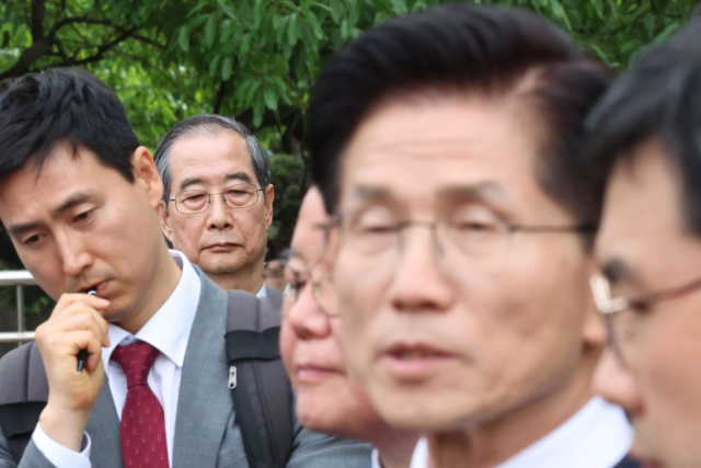 한덕수 무소속 대선 예비후보가 8일 서울 국회 사랑재에 위치한 커피숍에서 회동을 마친 후 김문수 후보의 백프리핑을 듣고 있다. 연합뉴스